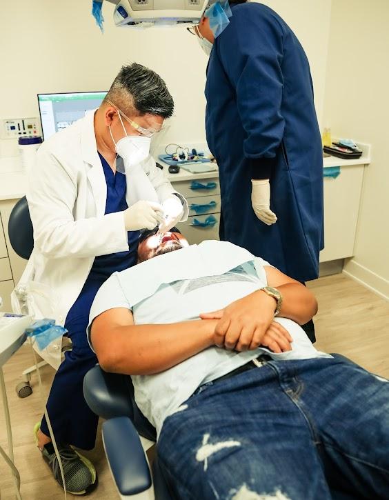 a man is getting his teeth examined by a dentist