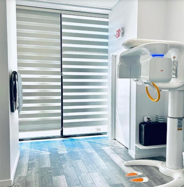 a dental office with a x-ray machine in the middle of the room .