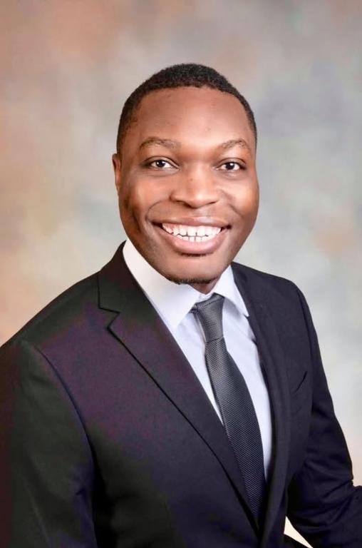 a man in a suit and tie is smiling for the camera