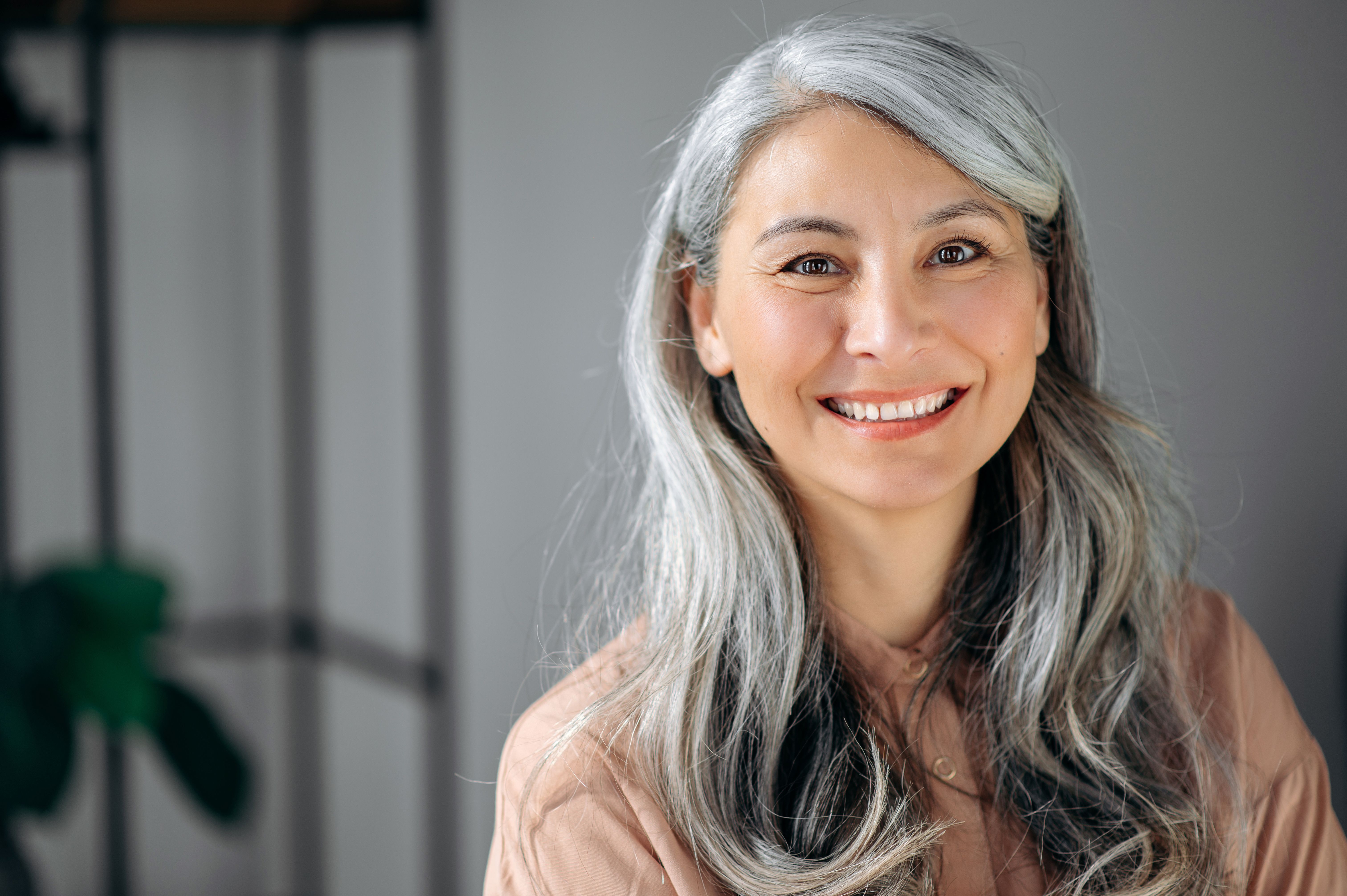a woman with gray hair is smiling for the camera .