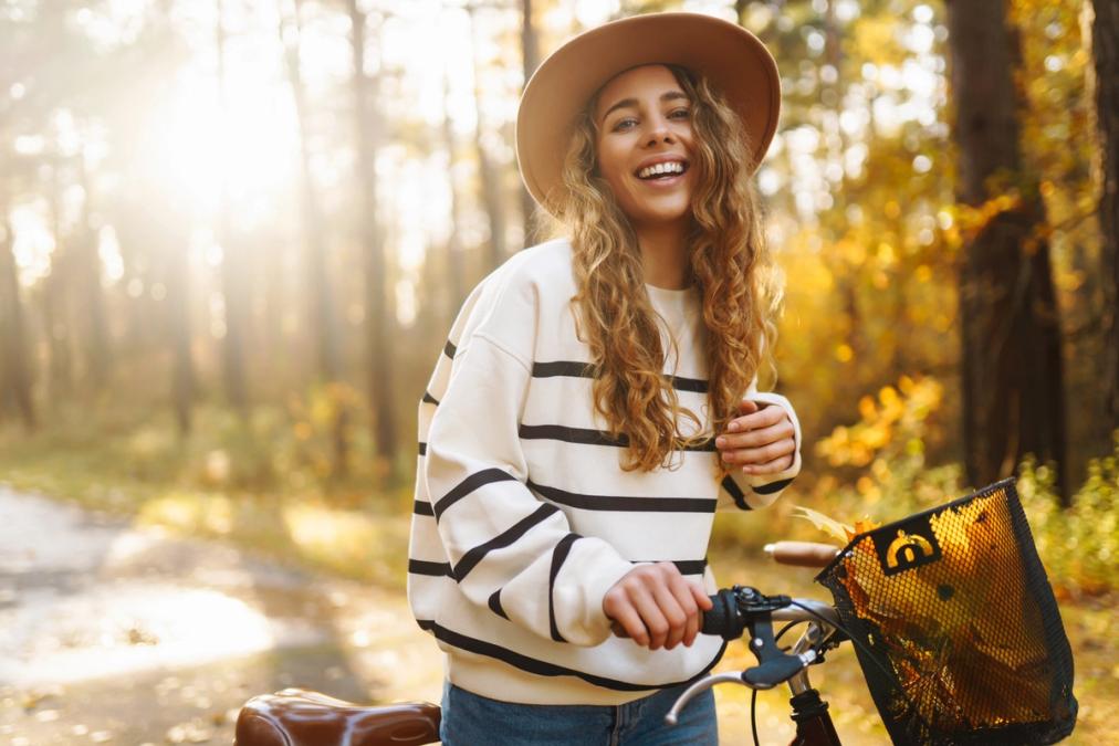 a woman is riding a bike in the woods and smiling .