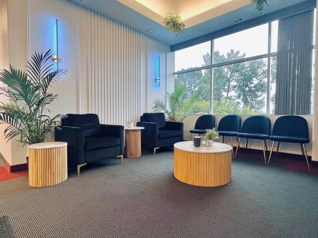a waiting room with chairs , tables and a coffee table .