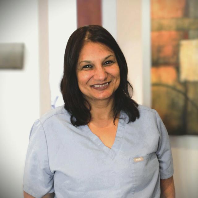 a woman wearing a scrub top with a name tag that says pda