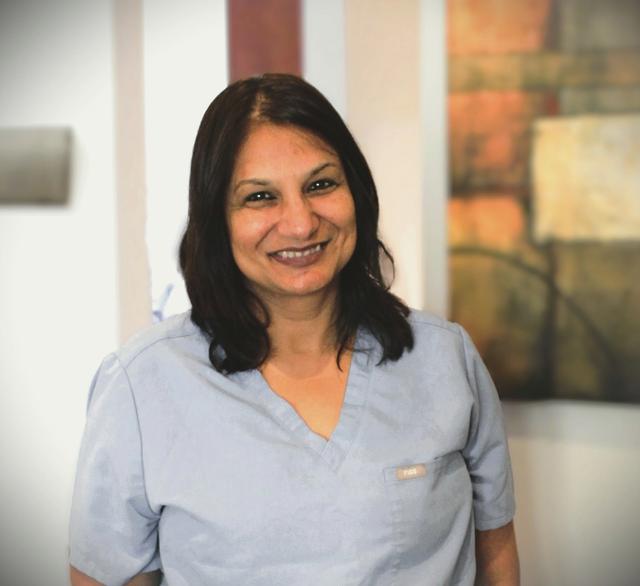 a woman wearing a scrub top with a name tag that says pda
