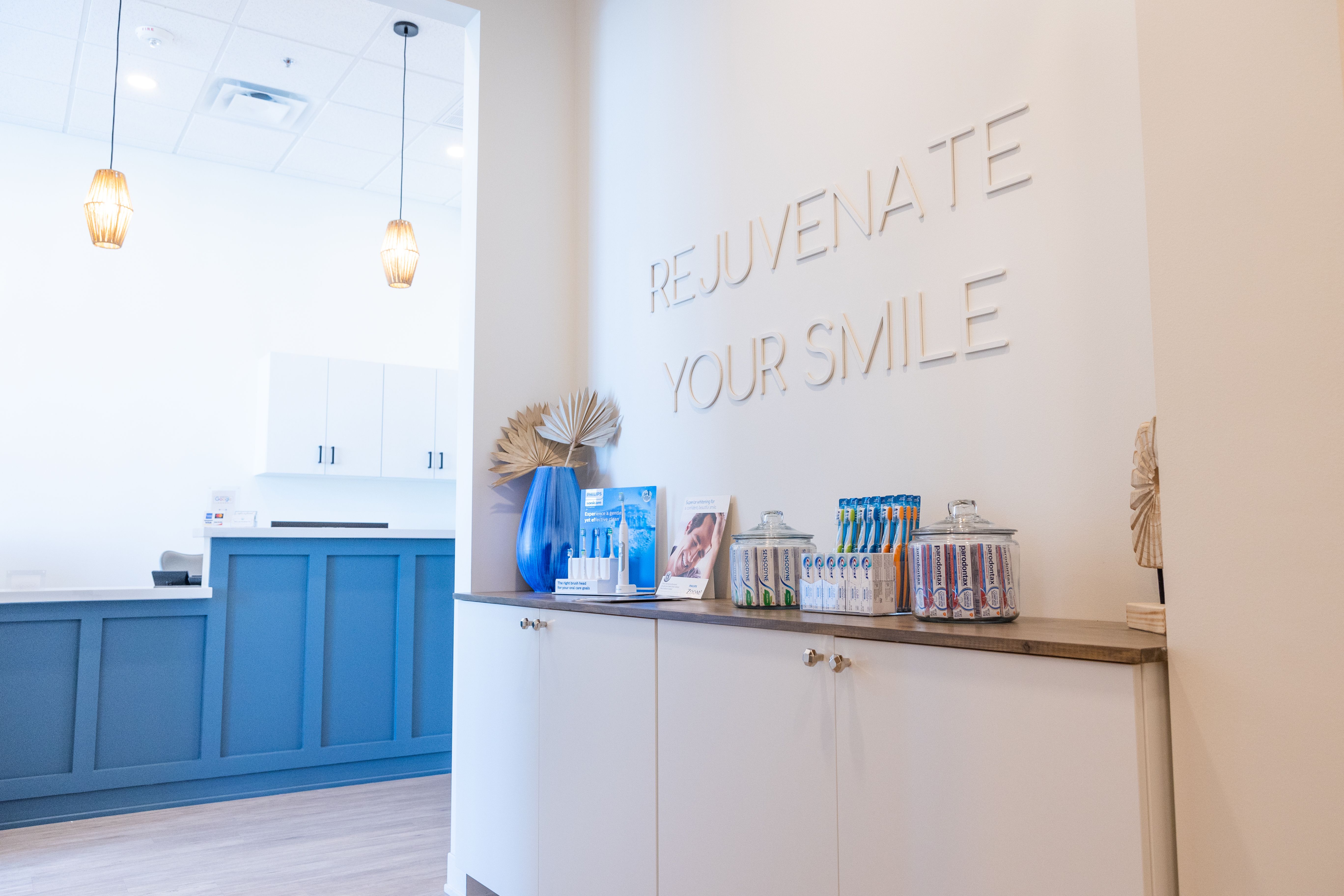 a dental office with a sign on the wall that says `` rejuvenate your smile '' .