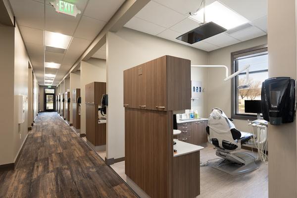 a dental office with a row of dental chairs in a hallway .
