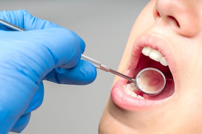 a woman is getting her teeth examined by a dentist .