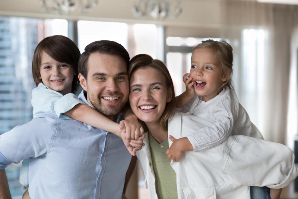 a happy family is posing for a picture together in a living room .