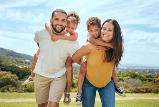a family is posing for a picture in a park .