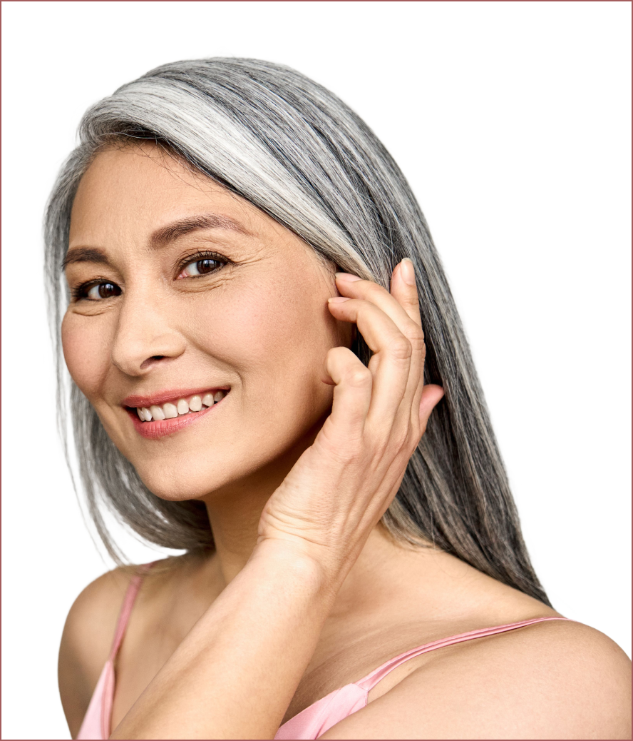 a woman with gray hair is smiling and touching her face