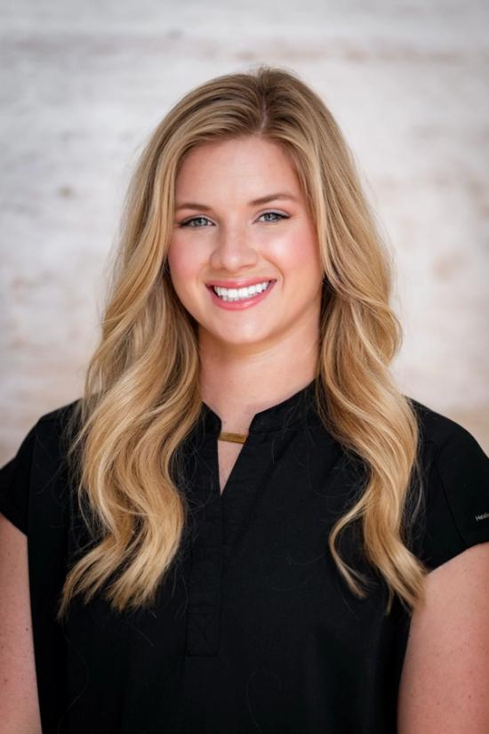 a woman in a black shirt is smiling for the camera