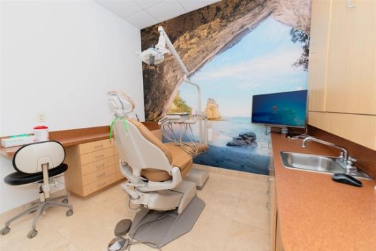 a dental office with a dental chair and a sink .