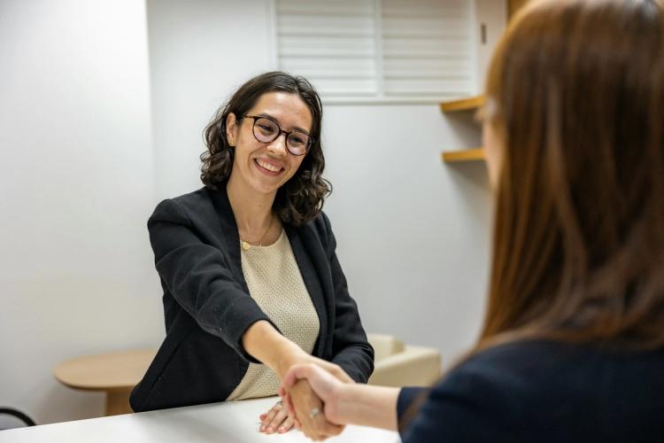 a woman is shaking hands with another woman during a job interview .