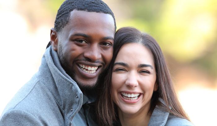 a man and a woman are smiling for the camera .