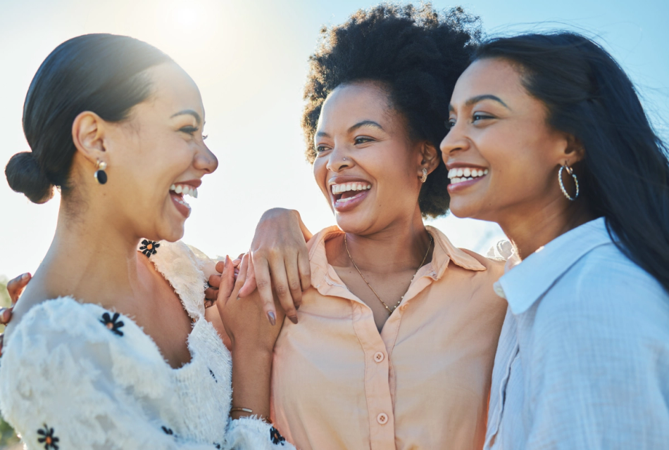 three women are laughing and hugging each other