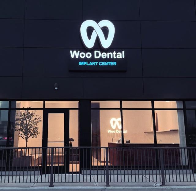the front of a dental office with a sign that says woo dental implant center .