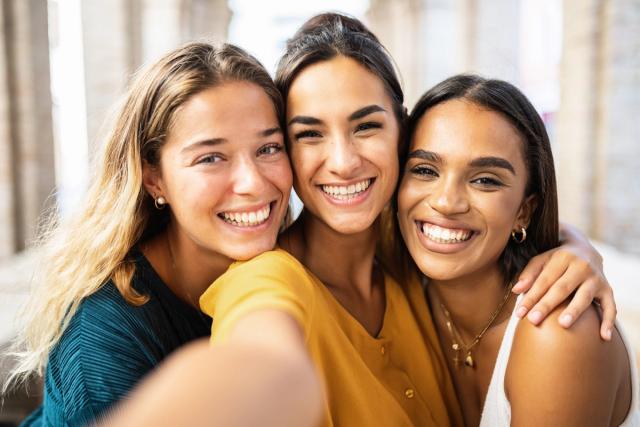 three women are taking a selfie together and smiling .