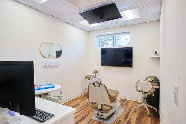 a dental office with a dental chair and a flat screen tv .