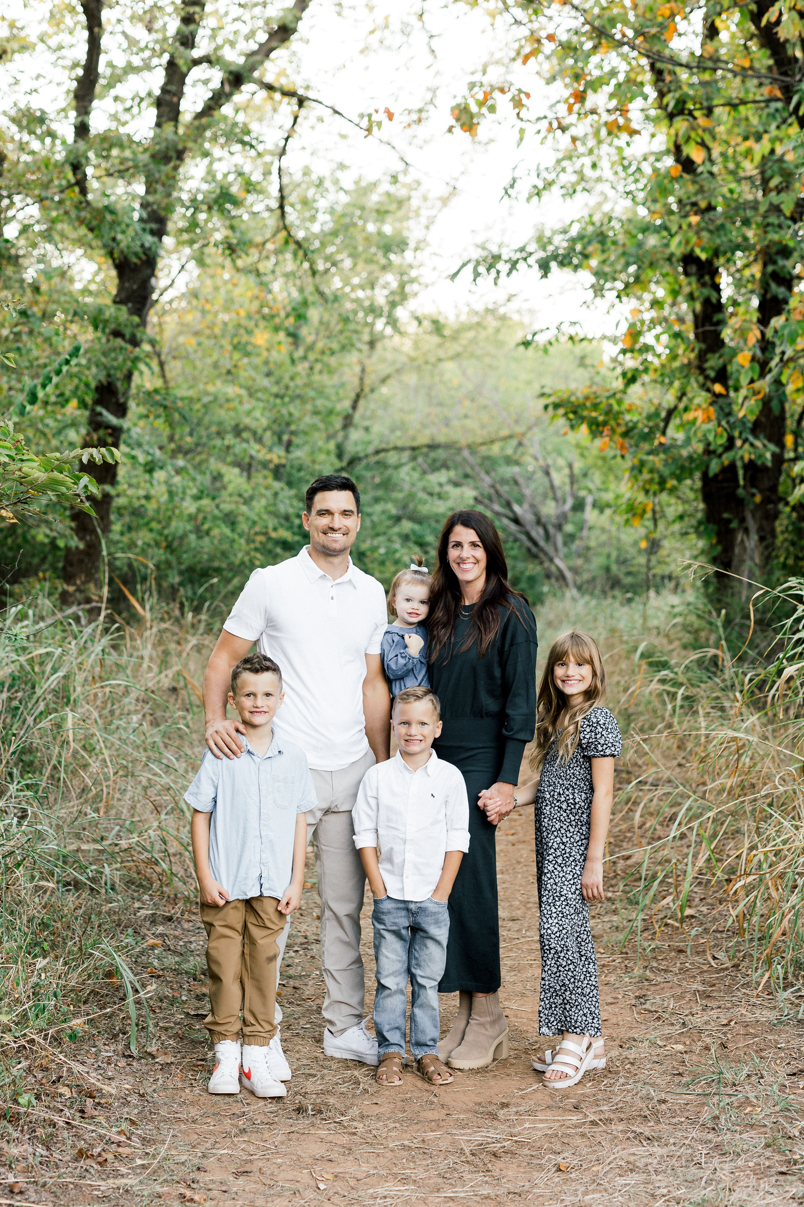 a family poses for a picture in the woods