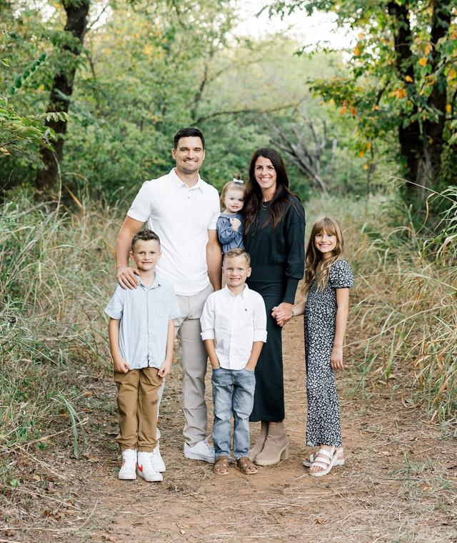 a family poses for a picture in the woods