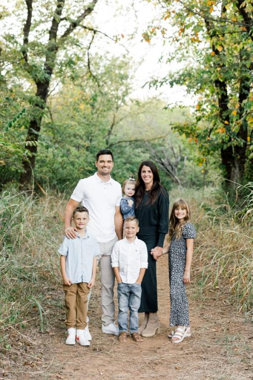 a family poses for a picture in the woods