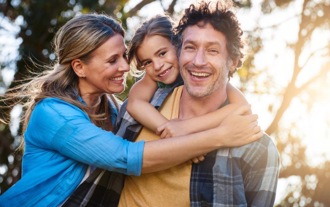 Happy family of three embracing outdoors.