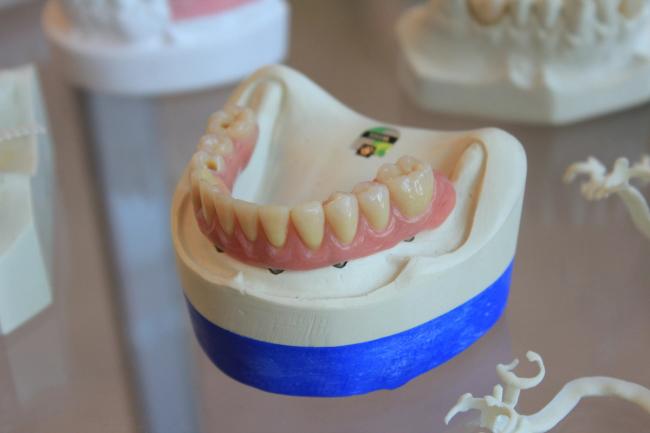 a woman is sitting in a dental chair while a dentist examines her teeth .