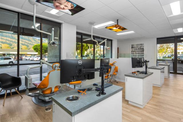 a dental office with a row of dental chairs and computers .