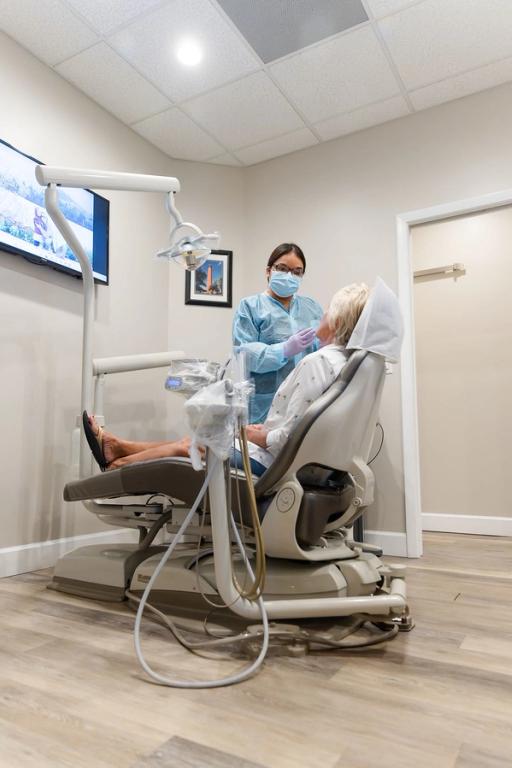 a woman is getting her teeth examined by a dentist