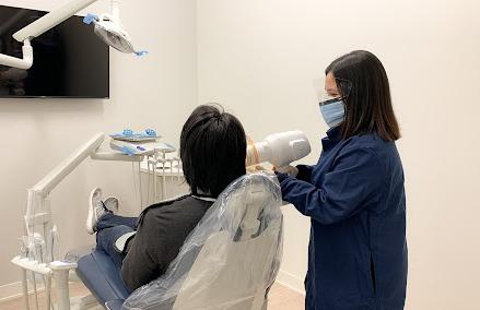 a dentist is taking an x-ray of a patient 's teeth in a dental office .