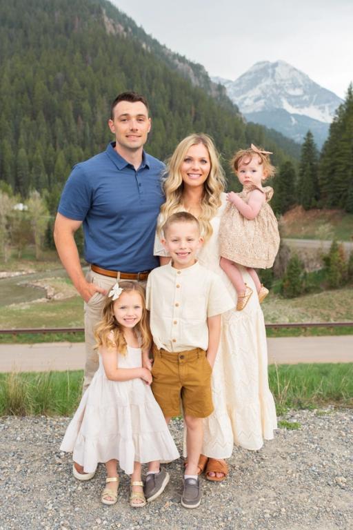 a family poses for a picture in front of a mountain .