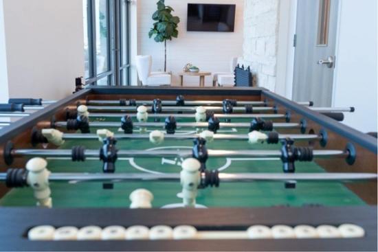 a foosball table is sitting in a living room next to a television .