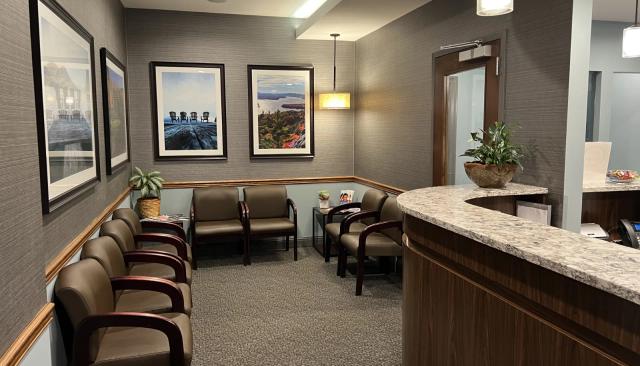 a waiting room with chairs and a counter in a dental office .