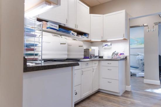 a kitchen with white cabinets , drawers , and a stove top oven .