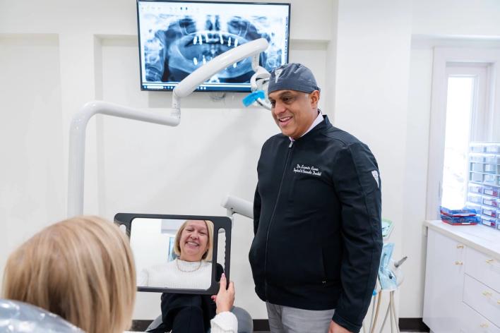 a dentist is talking to a patient in a dental office .