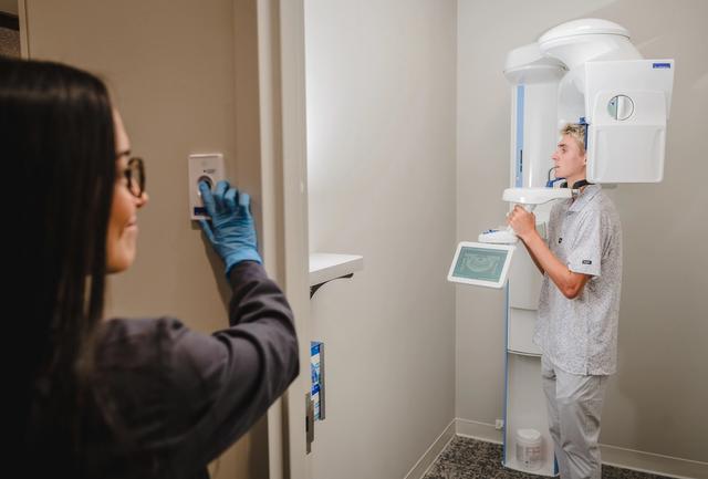 a man is getting an x-ray of his teeth in a dental office .