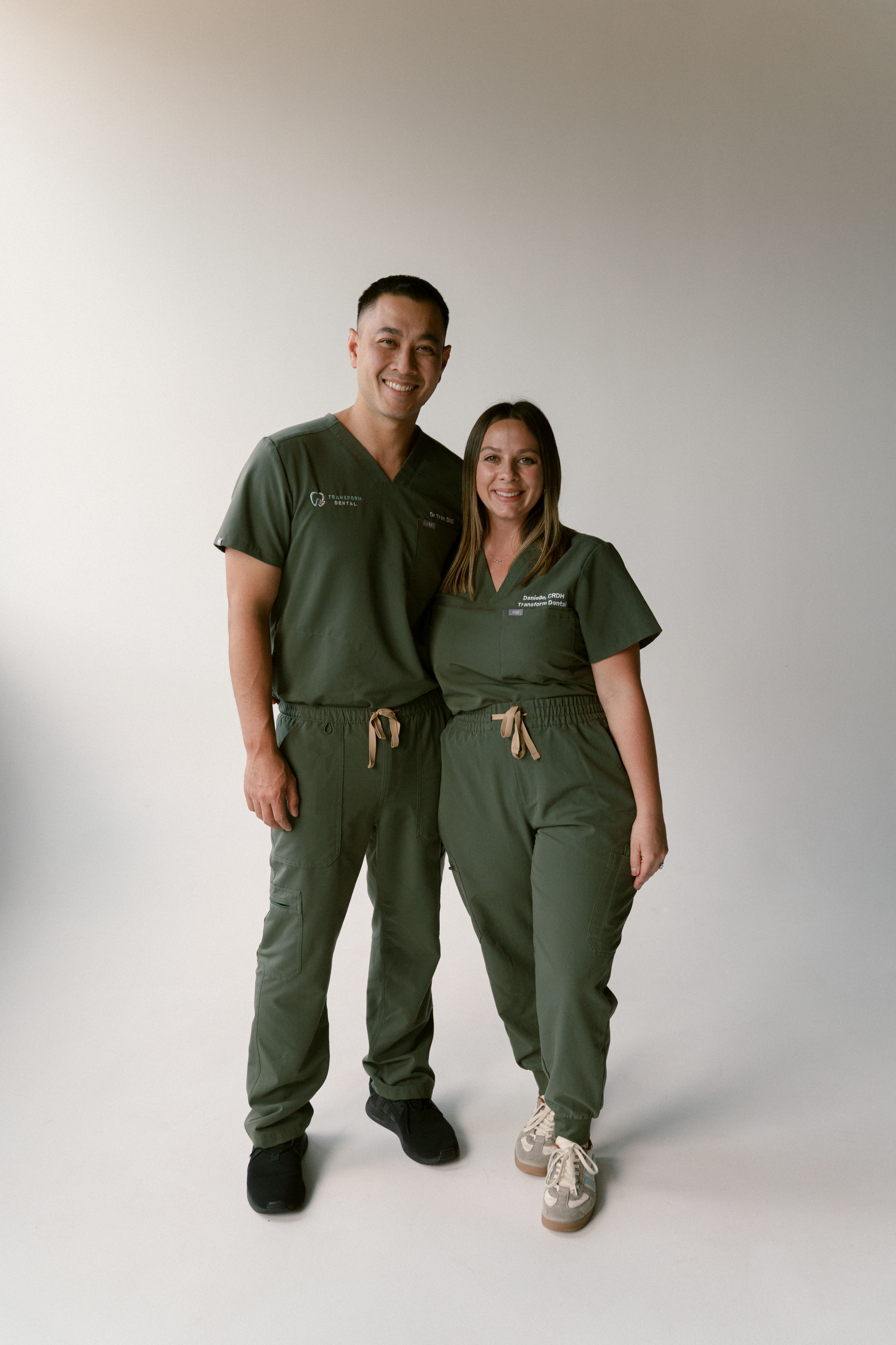 a man and a woman standing next to each other wearing scrubs