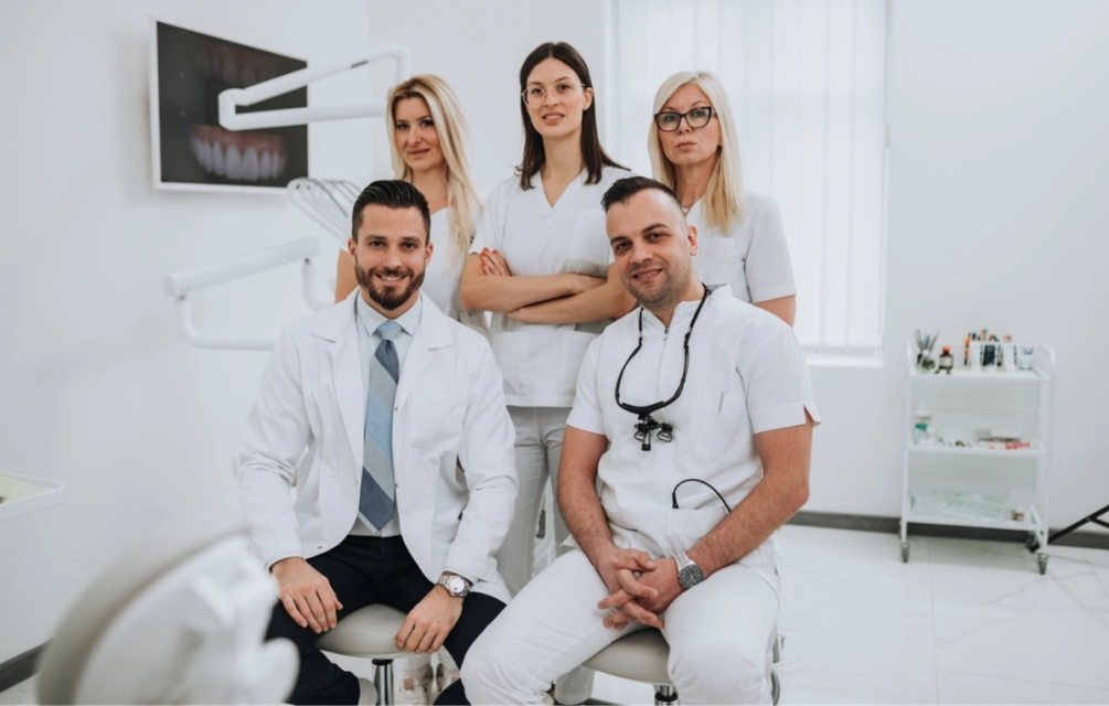 a group of dentists pose for a picture in a dental office