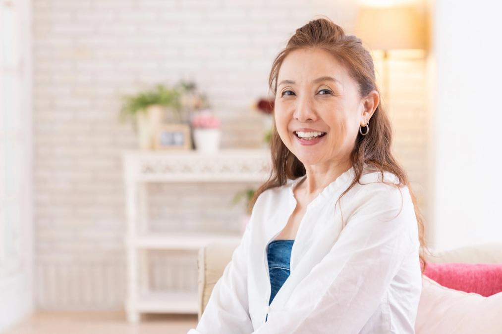 a woman is smiling while sitting on a couch in a living room .