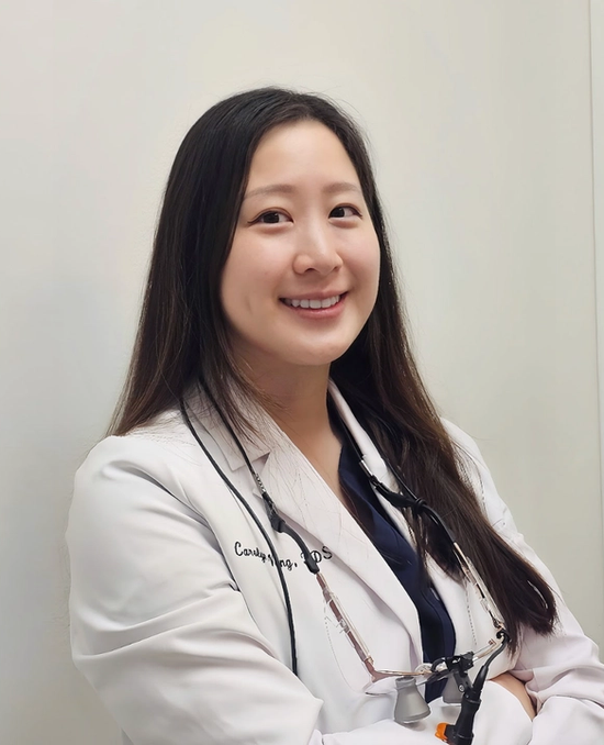 a woman in a white coat with the name candy on it