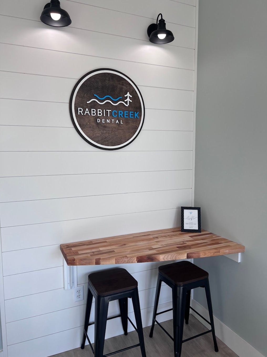 a rabbit creek dental sign hangs above a wooden table