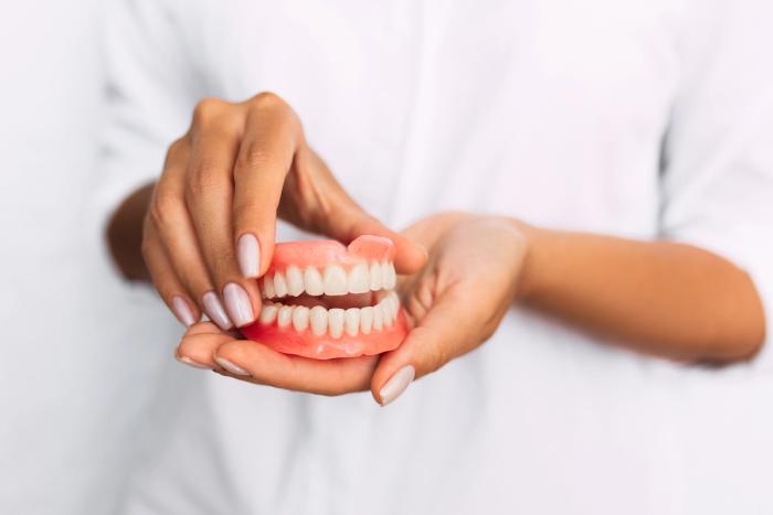 a woman is holding a model of her teeth in her hands .