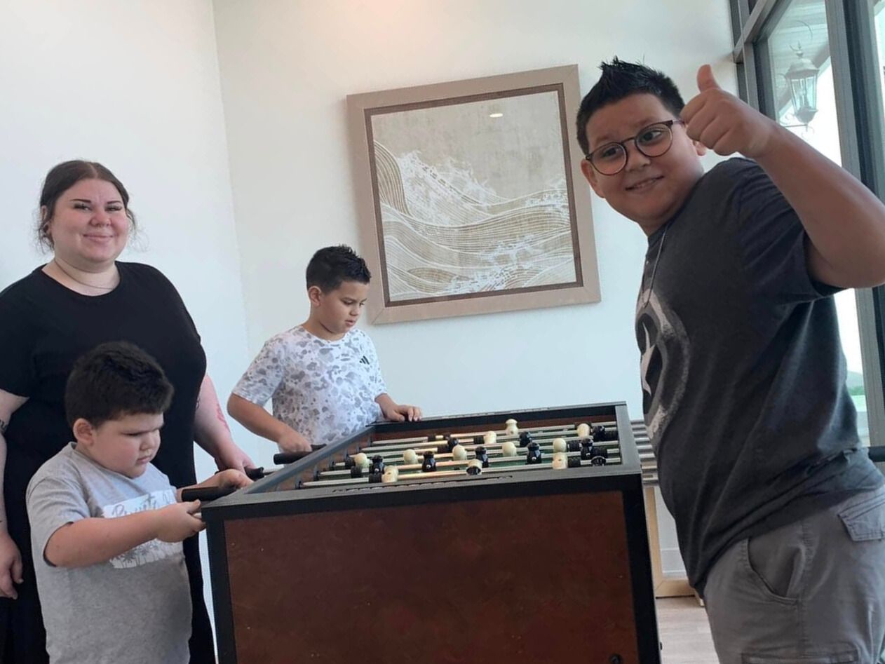 a family is playing a game of foosball in a living room .
