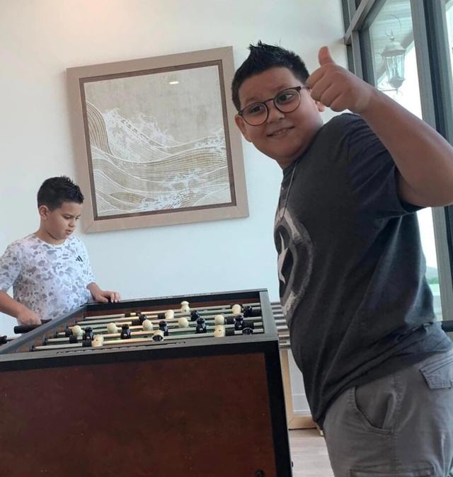 a family is playing a game of foosball in a living room .