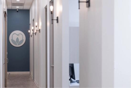 a long hallway in a dental office with a sign on the wall .