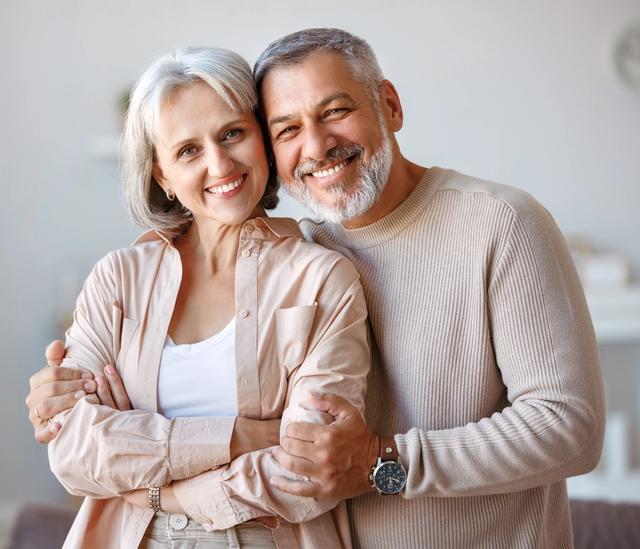 a man and a woman are hugging each other in a living room .