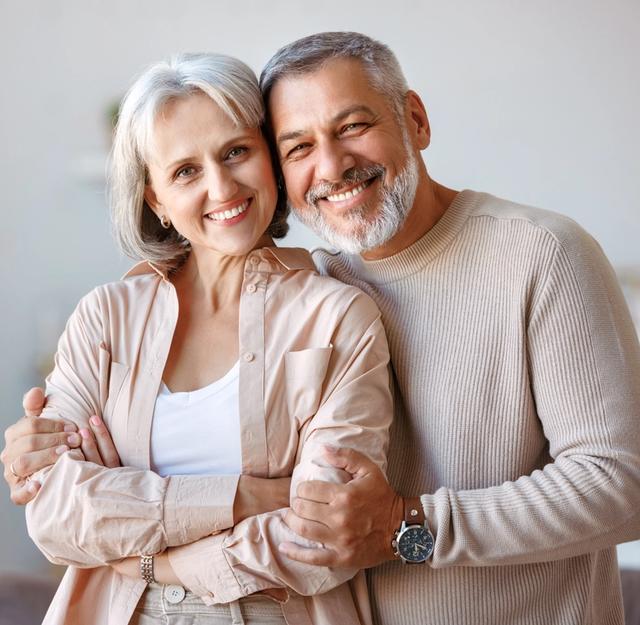 a man and a woman are hugging each other in a living room .