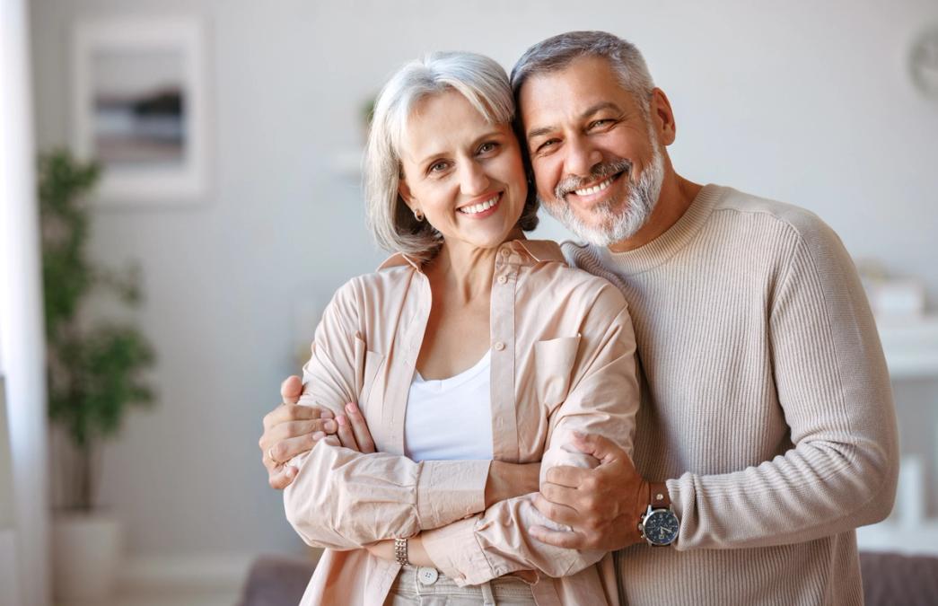 An older couple smiling and embracing.