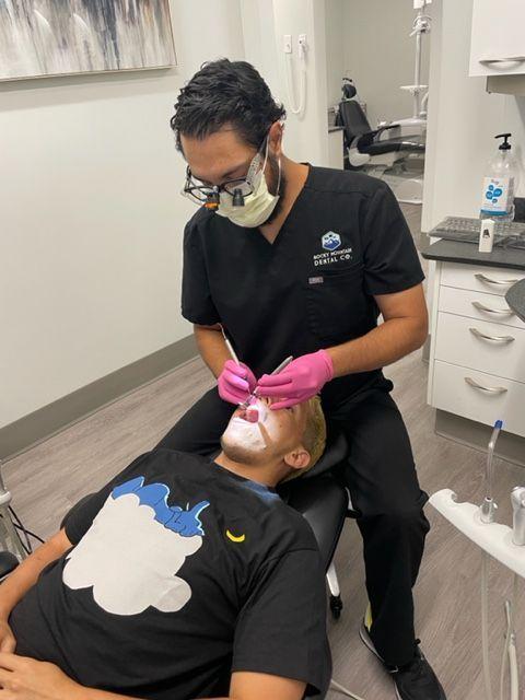 a man is getting his teeth examined by a dentist from royal co dental