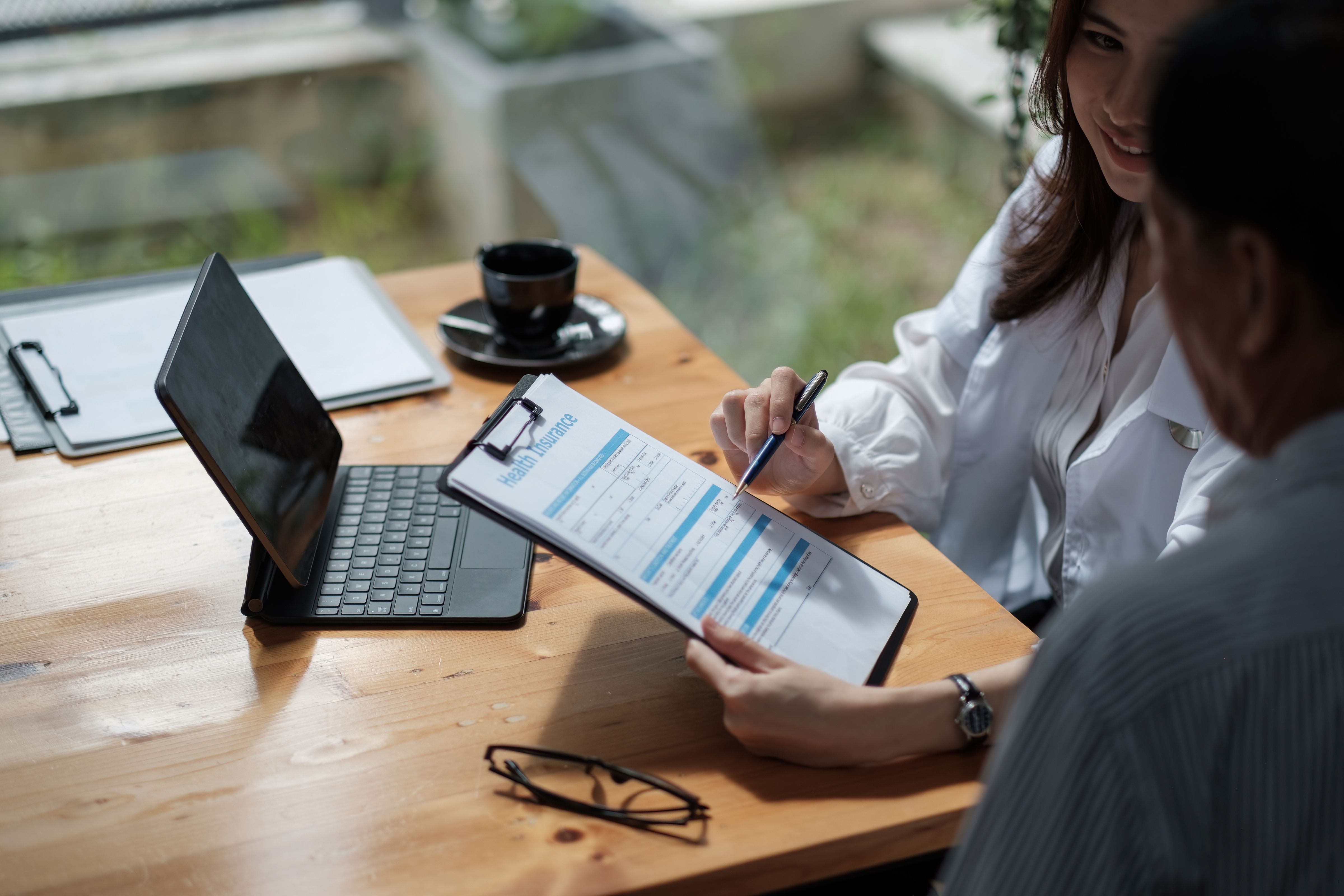 a man and a woman are sitting at a table looking at a resume .